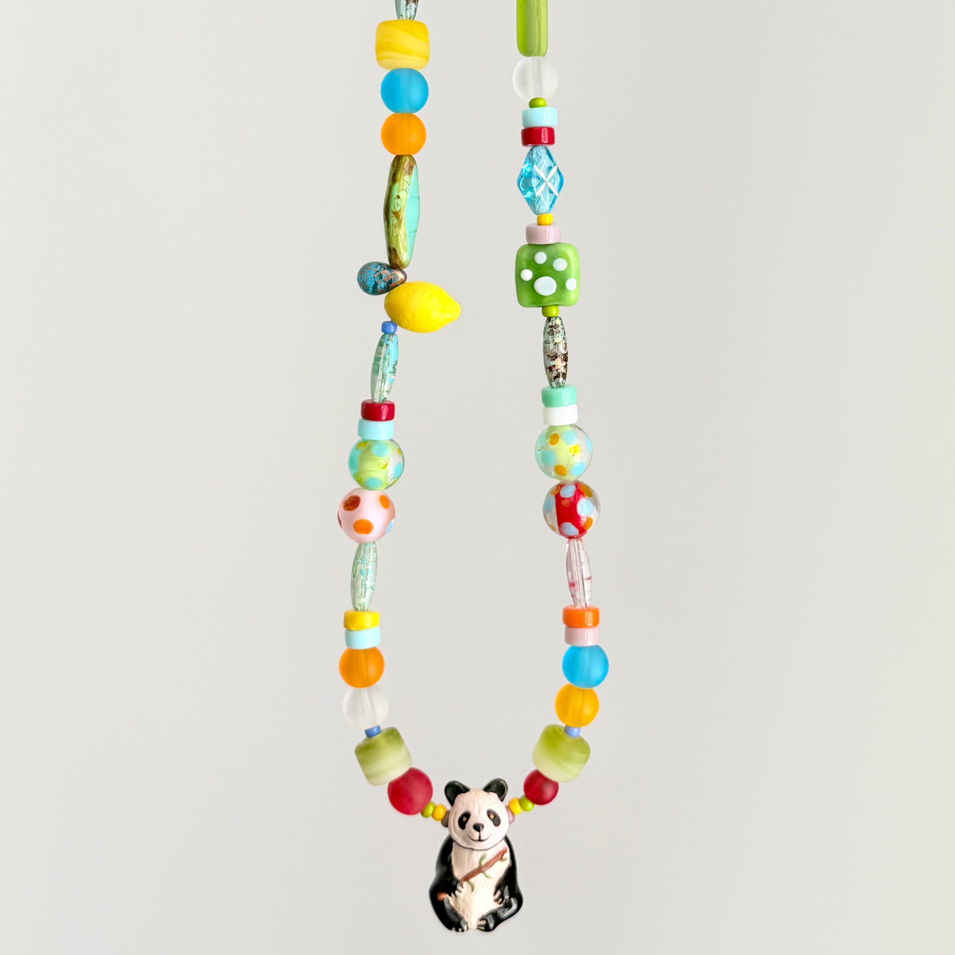 Colorful beaded necklace with a panda charm on a light gray background